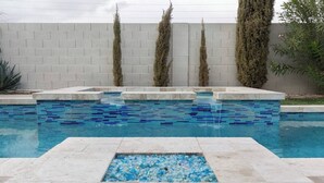 A swimming pool with blue mosaic tiles and a pebble accent in the center. - CASA MIA - Las Vegas traditional Luxury (Las Vegas)