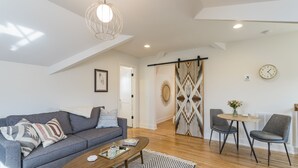 A modern living room with a grey sofa, a wooden coffee table, and two grey armchairs. - The Russell House - Walk to Restaurants & Bars! (Nashville)