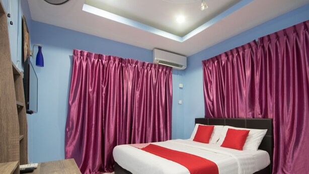 A bedroom with a bed, a desk, and curtains. - OYO 1103 Borneo Inn (Kota Kinabalu)