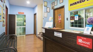 A reception area with a wooden counter, a sign for the Borneo Inn, and a 'Pay with Boost' sign. - OYO 1103 Borneo Inn (Kota Kinabalu)