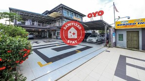 A building with a sign that reads "Sanitized Stay" and a large red circle with a white cross. - OYO 1103 Borneo Inn (Kota Kinabalu)