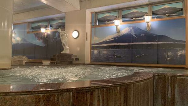 A spa area with a hot tub, a statue, and large windows with artwork. - Funabashi Grand Sauna and Capsule Hotel - Caters to Men (Funabashi)