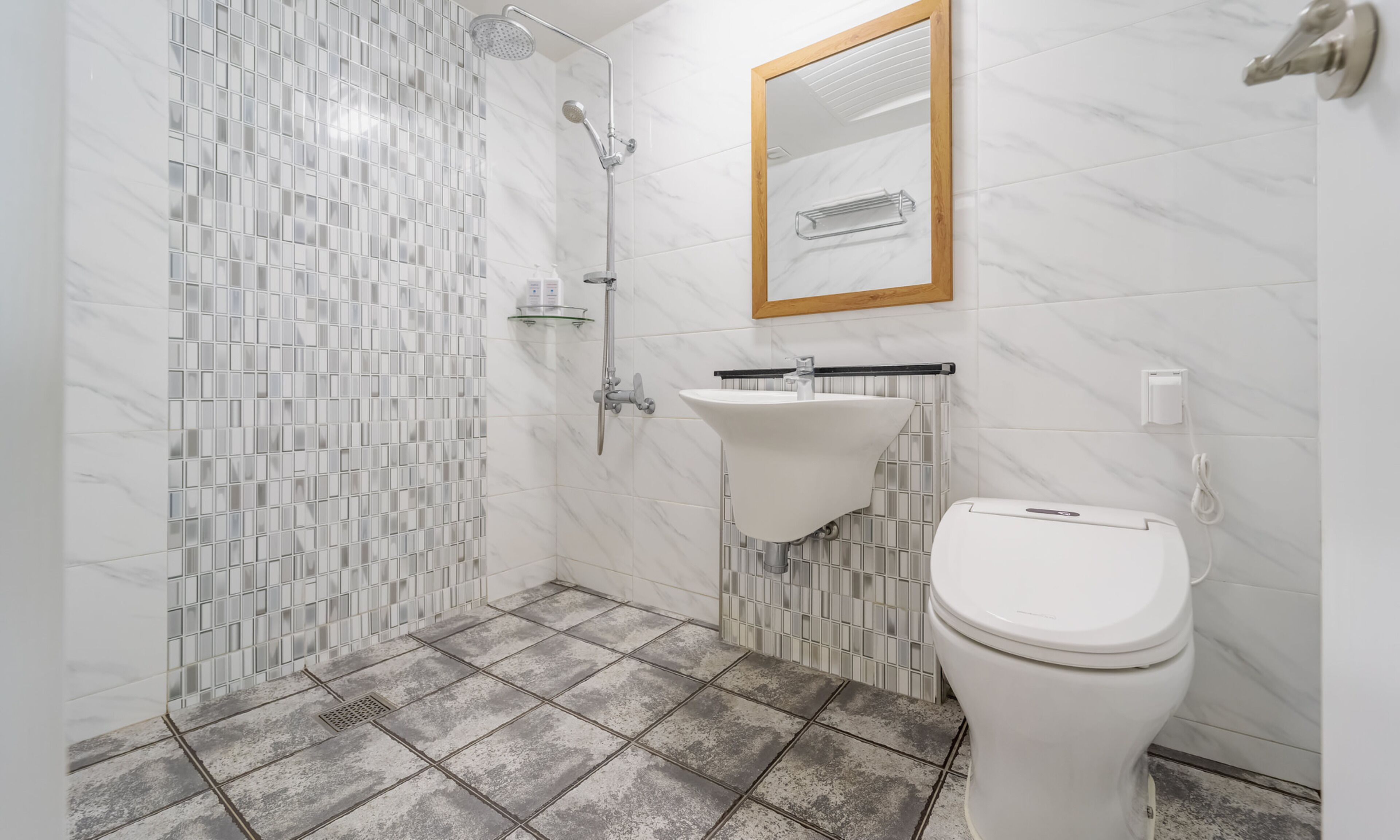 A bathroom with a shower, sink, and toilet.