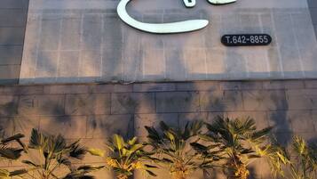 A hostel sign with Korean characters and a contact number.