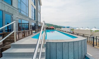 Una piscina al aire libre de temporada, sombrillas