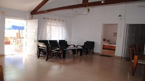 Un salón espacioso con suelo de madera, un conjunto de sofás y una mesa de comedor con sillas.