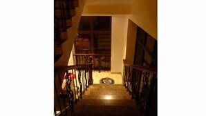 Una escalera con barandillas de madera y un rellano alfombrado.