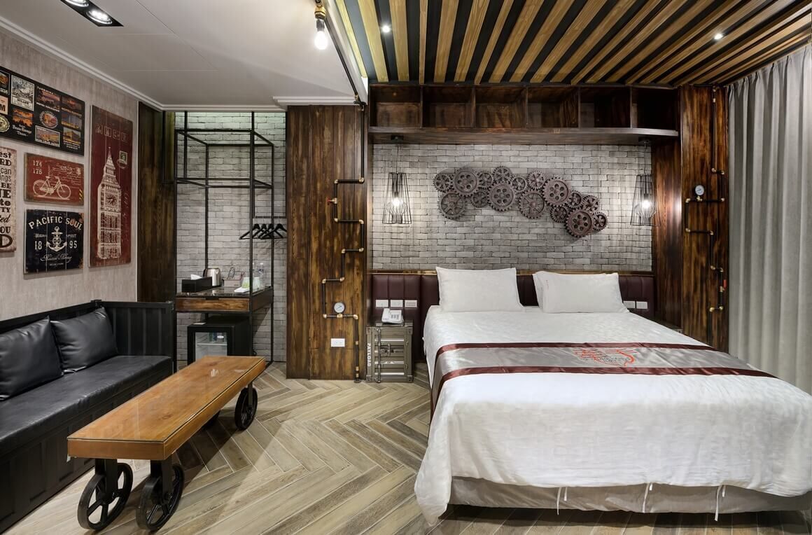 Un dormitorio moderno con una cama grande, un banco de madera y un escritorio con una silla.