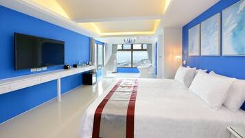 Une chambre d’hôtel moderne dotée d’un grand lit, d’un téléviseur à écran plat et offrant une vue sur la ville grâce à de grandes fenêtres.