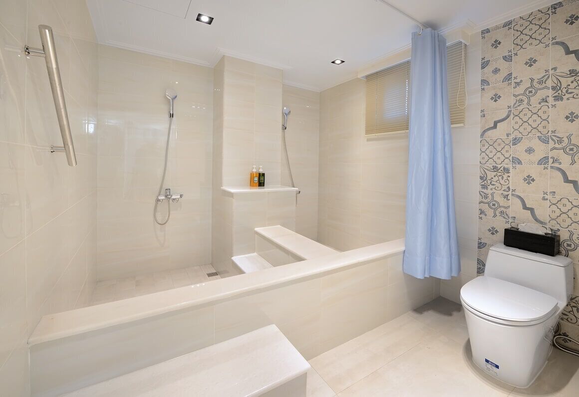 Een moderne badkamer met een badkuip, douche en toilet.