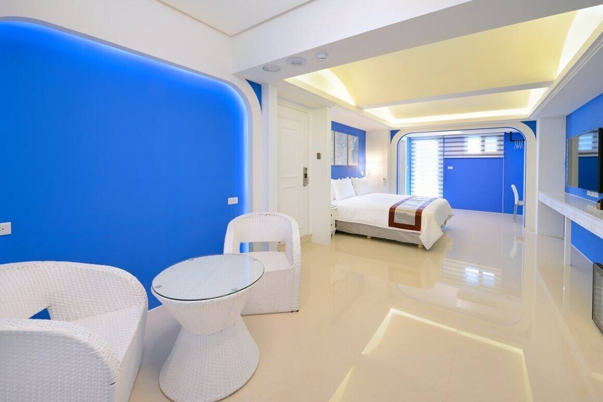 Una habitación de hotel moderna con cama, una mesita y dos sillas.