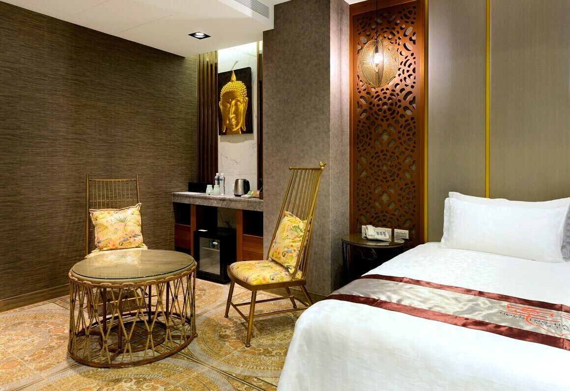 Une chambre d’hôtel avec un lit, deux chaises, un bureau et une salle de bain.