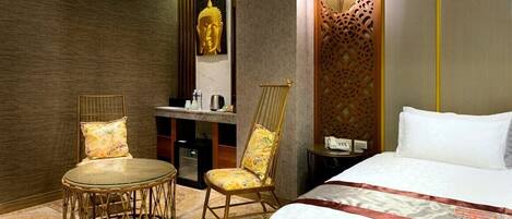 Une chambre d’hôtel avec un lit, deux chaises, un bureau et une salle de bain.