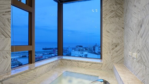 A spa area with a large window offering a city view. - Hand in Hand INN (Liuqiu)