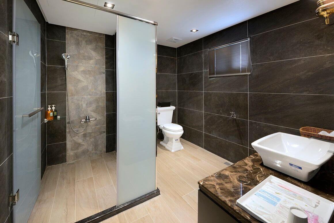 Un bagno moderno con box doccia in vetro, un water bianco e una grande vasca da bagno.