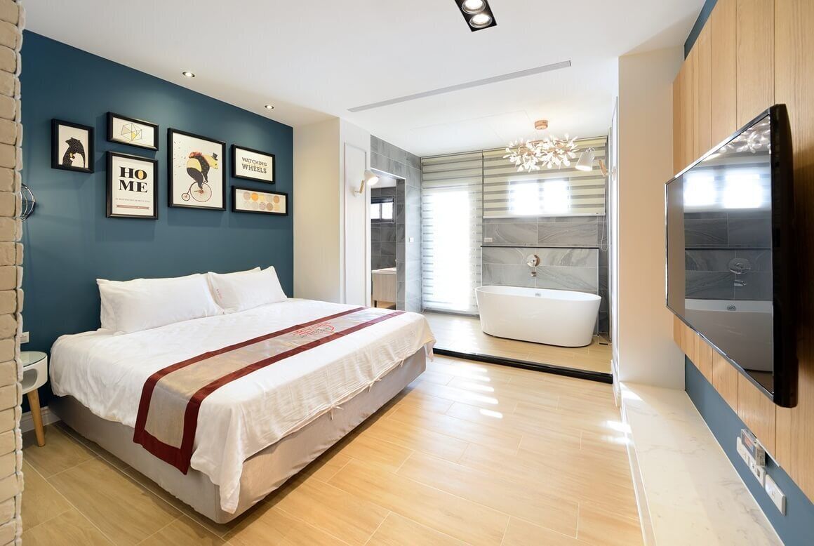 Un dormitorio moderno con una cama grande, una bañera y un televisor.