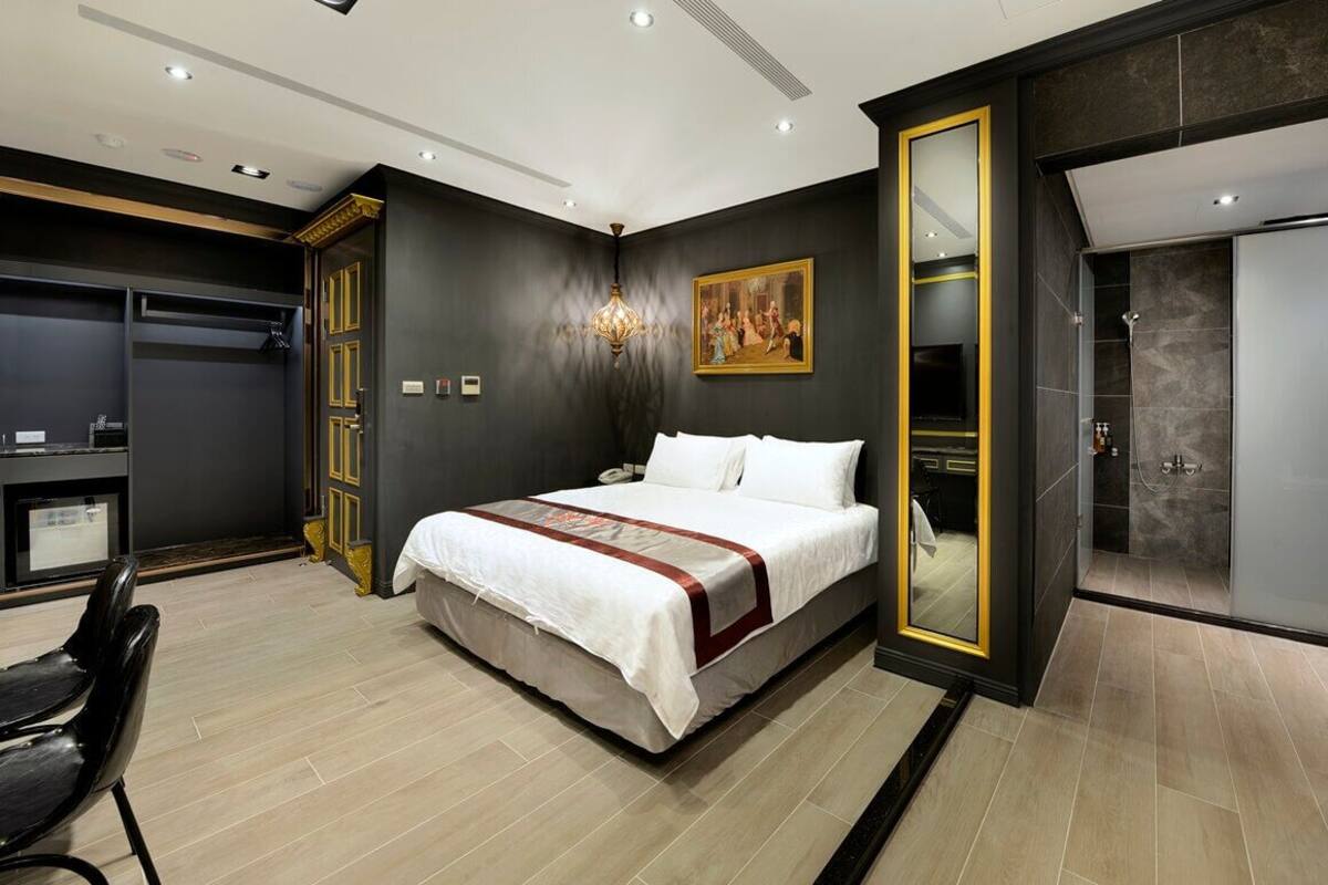 Una habitación de hotel moderna con una cama grande, un escritorio y un vestidor.