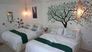 A hotel room with two beds, a wall mural of a tree, and decorative wall stickers. - Cronin Inn by Cocotel (Oslob)