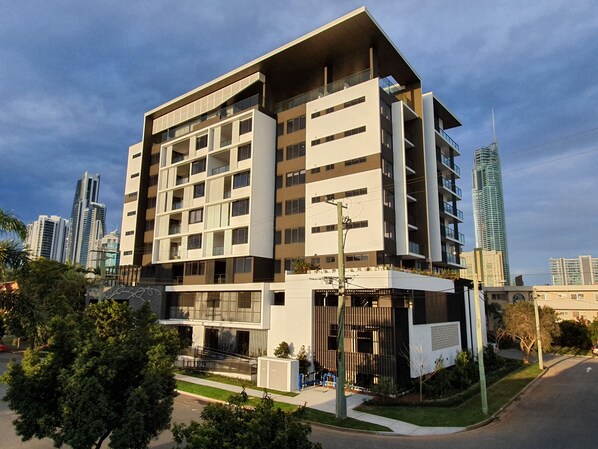 A modern multi-story building with a flat roof, large windows, and a balcony on the upper floors. - Peninsular GoldCoast (Surfers Paradise)