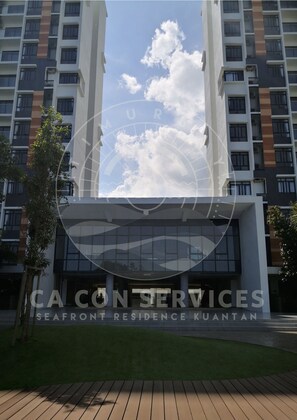 A modern building with a glass facade, likely a hotel or residential complex, with a clear sky and clouds in the background. - TimurBay Seaview Stunning By CA CON (Kuantan)