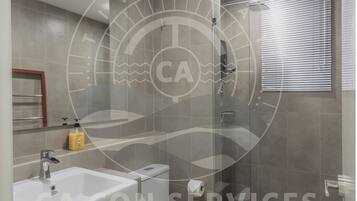 A modern bathroom with a bathtub, sink, and toilet.