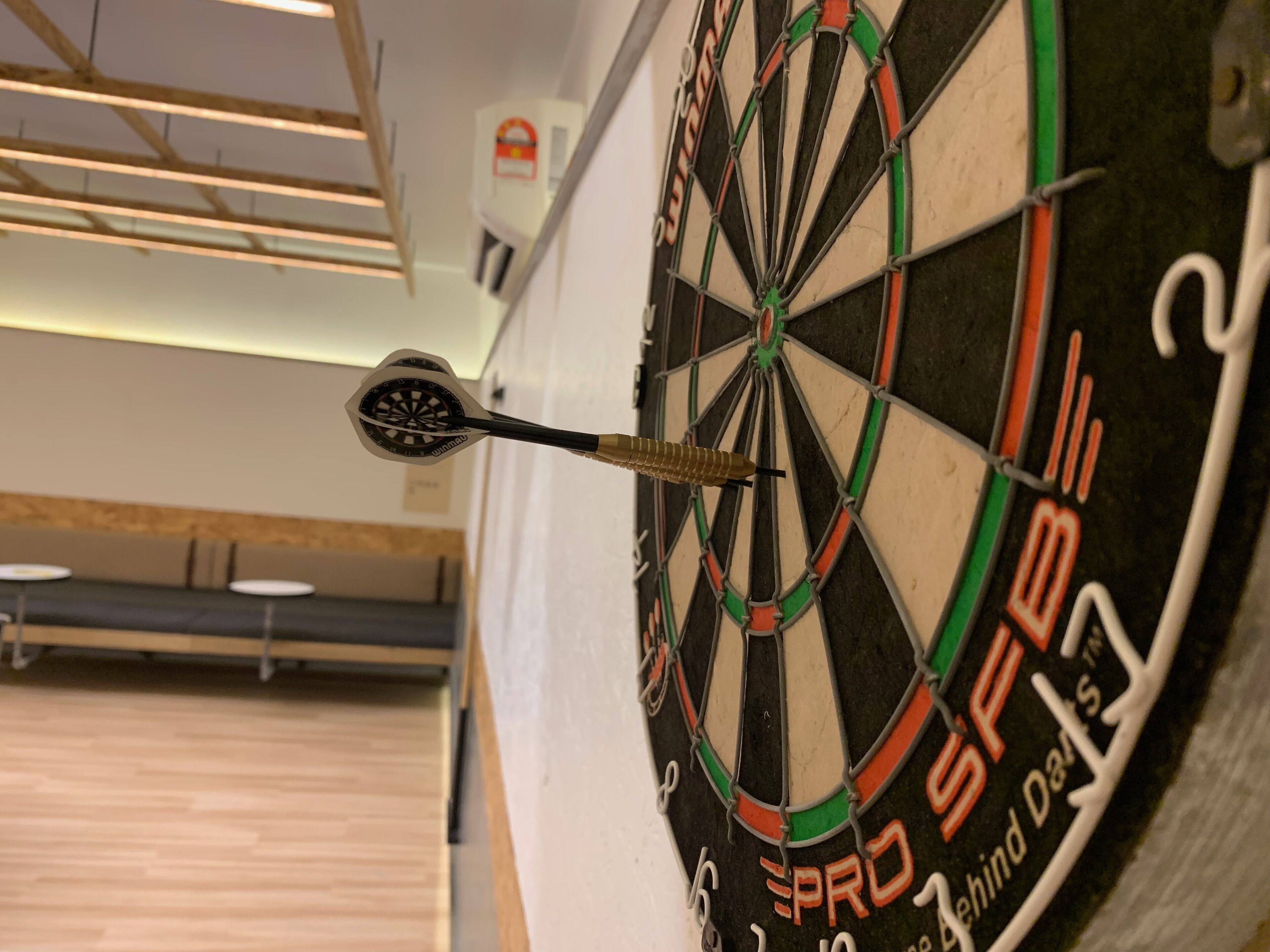 A dartboard with a dart in the center, mounted on a wall.