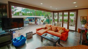 A modern living room with a large TV, a sofa, a coffee table, and a blue bean bag. - Orza - holiday home with private swimming pool in Benissa (Benissa)