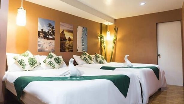 A hotel room with two beds, a green and white bedspread, and a wall with three framed pictures. - El Moro Beach Resort by Cocotel (Boracay Island)