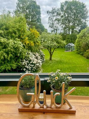A wooden table with a metal sign spelling 'Glick' and two potted plants.