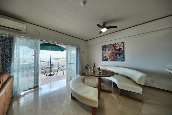 A modern living room with a curved white sofa, a round coffee table, and a ceiling fan.