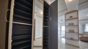 A modern interior with a built-in closet featuring multiple shelves and a sliding door. - FreedomHills A (Tomigusuku)