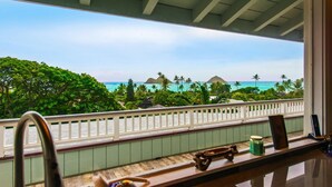 Ein Balkon mit Blick auf das Meer und Palmen.