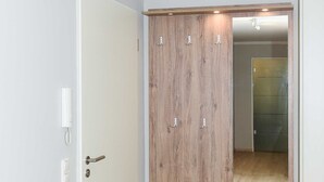 A room with a wooden wardrobe, a white door, and a light-colored floor. - Vacation apartment 14 - Haus Seeperle (Esens)