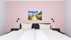 A double bed with white linens, a headboard, and bedside tables with lamps. - Vacation apartment 18 - Haus Seeperle (Esens)