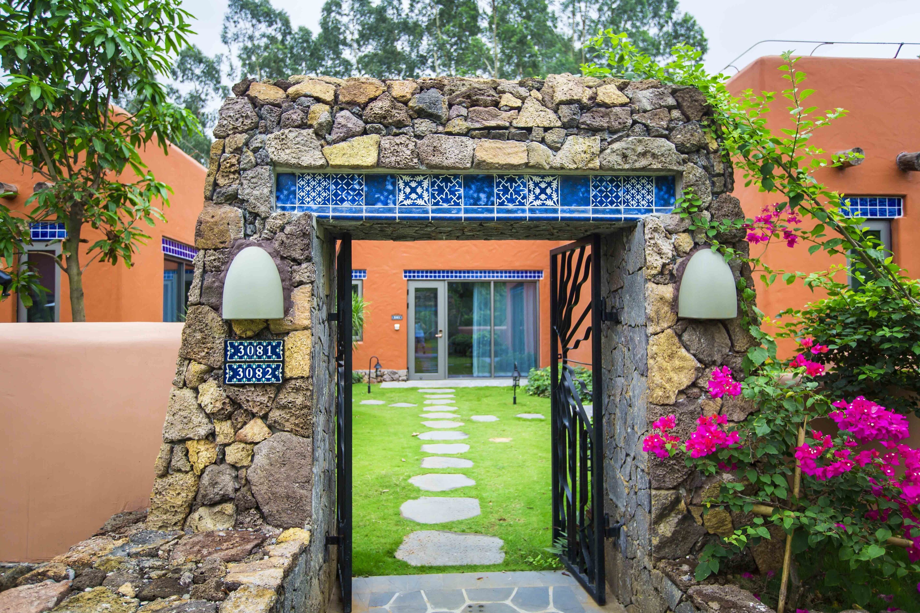 A stone archway with a tiled border leading to a building entrance.