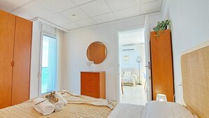 Ein Schlafzimmer mit einem Bett, einem Holzschrank, einem Schminktisch und einem Spiegel an der Wand.