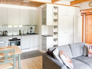A compact kitchen with white cabinets, a built-in oven, and a sink. - Levin rinnelinna a8 by Interhome (Kittilä)