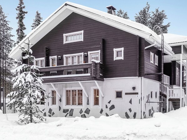 A two-story building with a balcony, surrounded by snow-covered trees. - Levin rinnelinna a8 by Interhome (Kittilä)