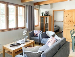 A cozy living room with a grey sofa, two armchairs, a wooden table, and a cabinet with glass doors. - Levin rinnelinna a8 by Interhome (Kittilä)