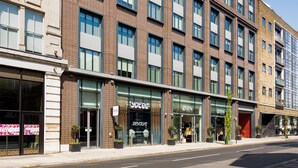 A multi-story hotel with a brick facade, large windows, and storefronts for businesses like 'Yotel' and 'ORN Furniture'. - Yotel London City (London)