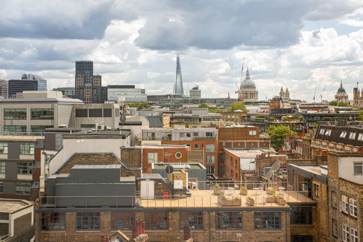 A cityscape with modern and historic buildings, including a prominent skyscraper and a dome structure.