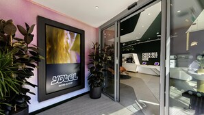 A modern hotel entrance with a large digital display advertising 'Yotel Non-Stop'. - Yotel London City (London)