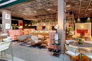 A modern lounge area with seating, tables, and a bar.