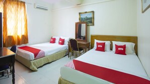 Une chambre d’hôtel avec deux lits simples, un bureau, une chaise et un miroir.