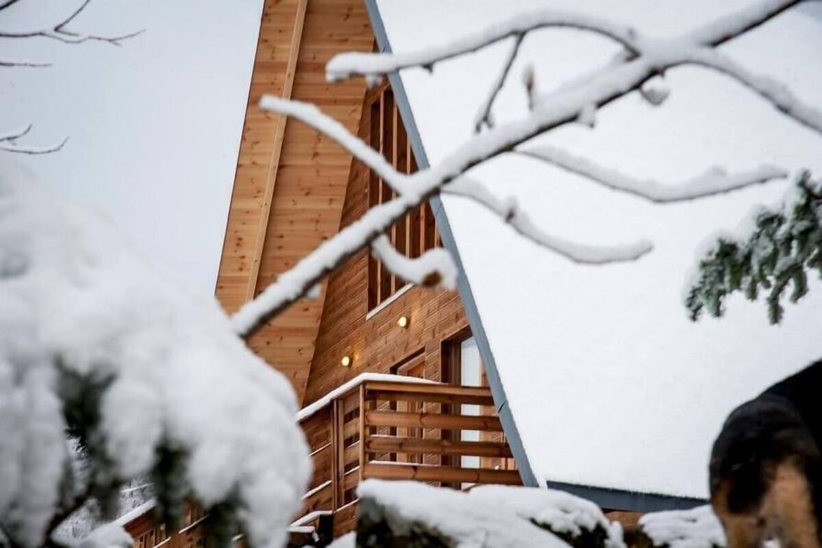 Eine Holzhütte mit geneigtem Dach und einer Holzterrasse.