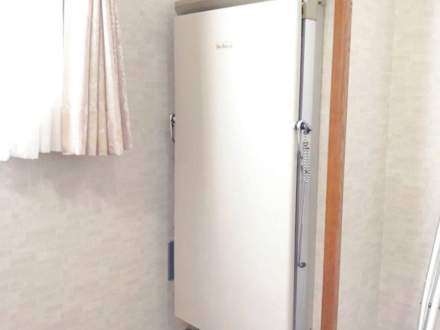 Een badkamer met een witte deur, een douchegedeelte en een paars tapijt op de vloer.