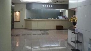 A modern hotel lobby with a reception desk, a large skylight, and a minimalist design. - Hotel River Inn (Nagaoka)