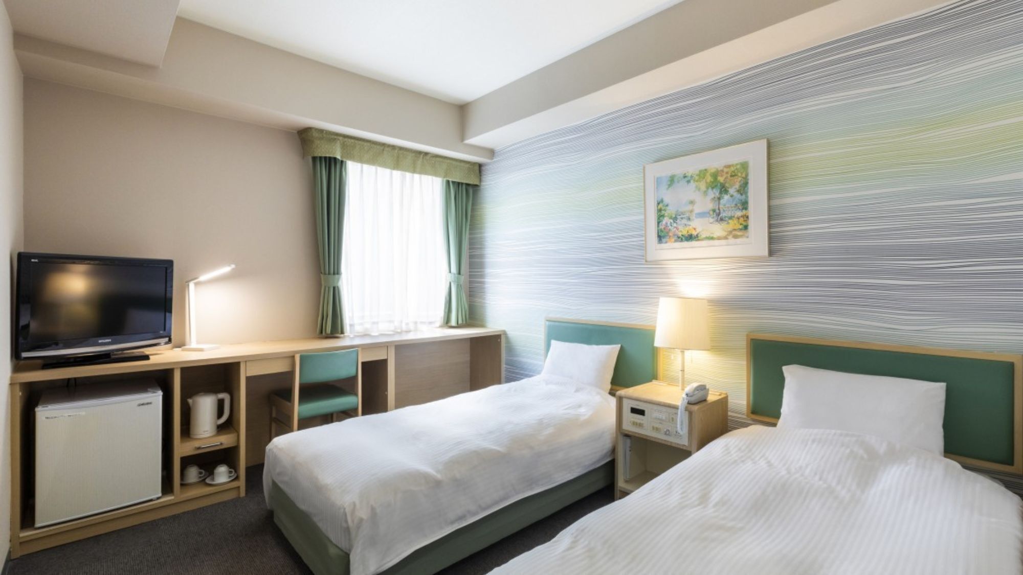 Habitación de hotel con dos camas, un televisor, un escritorio y un cuadro en la pared.