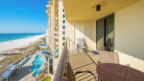 A balcony with a view of the beach, a pool, and a dining area. - **WEEKLY SPECIALS!** Phoenix II - 7th Floor - 2 Bedroom (Orange Beach)