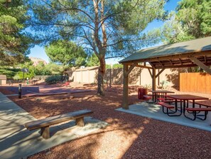 An outdoor patio area with picnic tables and a covered seating area. - Stylish Sedona Condo | Red Rock Views, Modern Comfort & Quiet Location (Sedona)